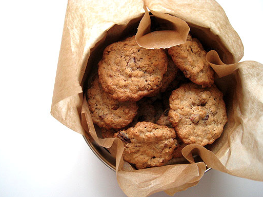 A batch of golden gluten and dairy free cookies in a tin lined with baking paper